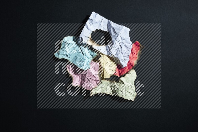 Burnt multicolored paper on black background