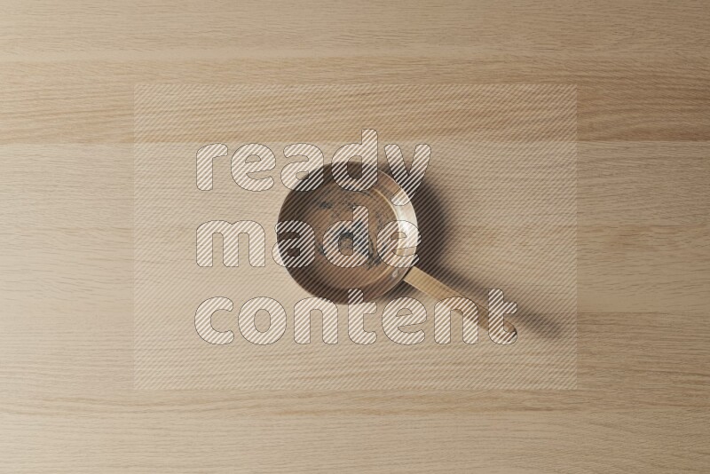 A small copper pan on light wooden background