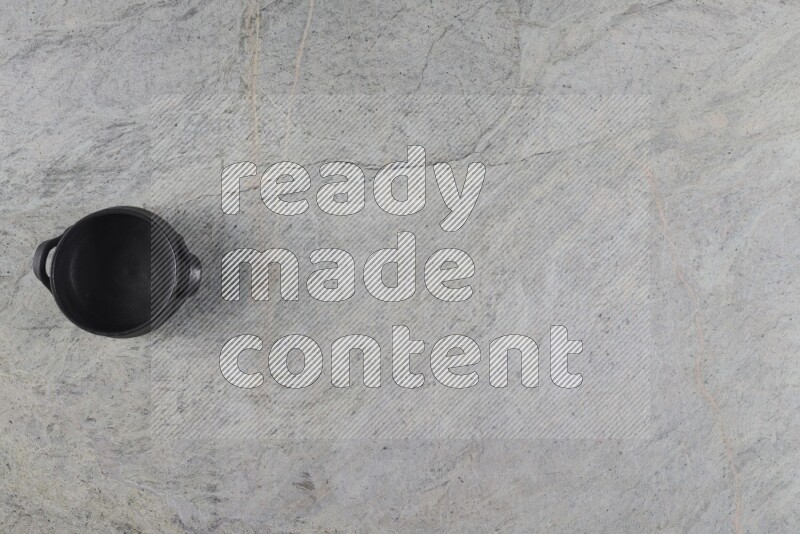 A black pottery bowl on grey marble background