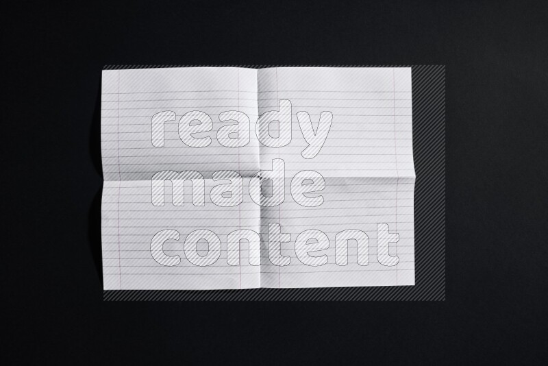 Folded notebook sheet on black background