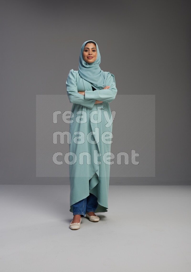 Saudi Woman wearing Abaya standing with crossed arms on Gray background