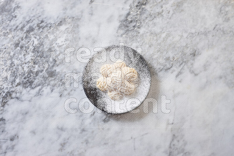 Kahk in black pottery plate on grey marble background