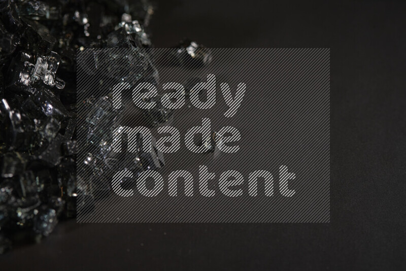 قطع زجاج سوداء شفافة متناثرة على خلفية سوداء