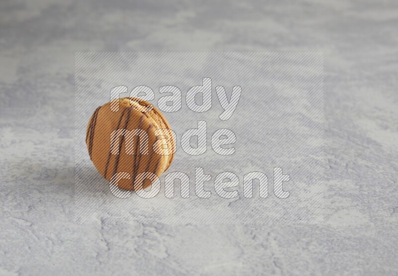 45º Shot of light brown  Almond Cream macaron on white  marble background