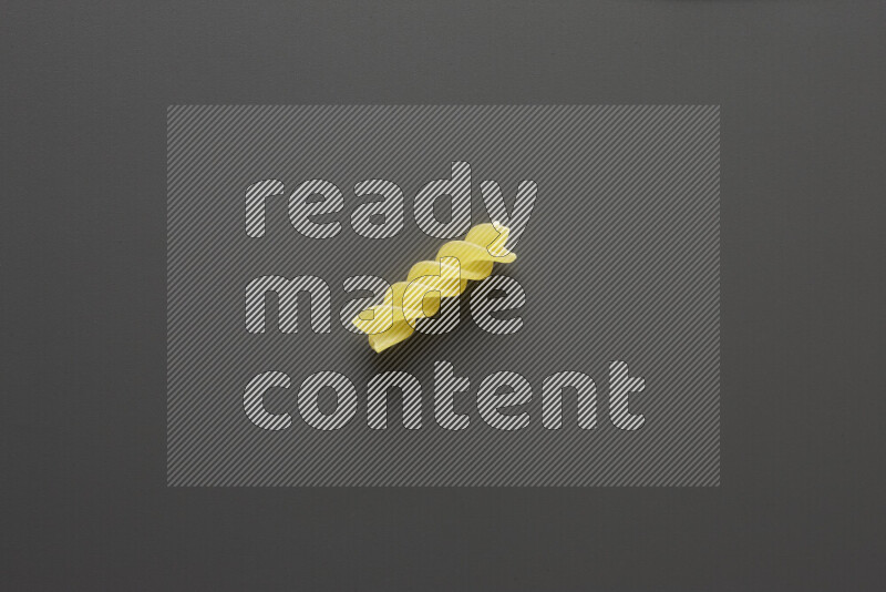 Fusilli pasta on grey background