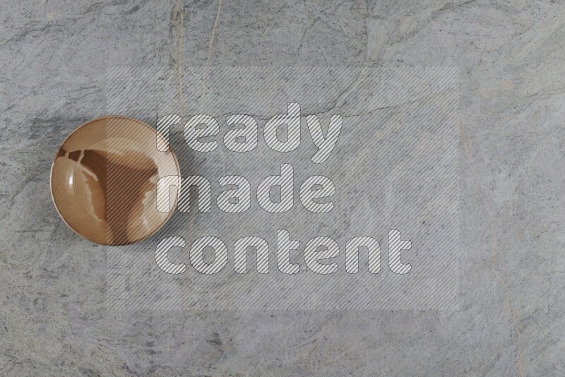 صحن فخاري متعدد الألوان على خلفية من الرخام الرمادي