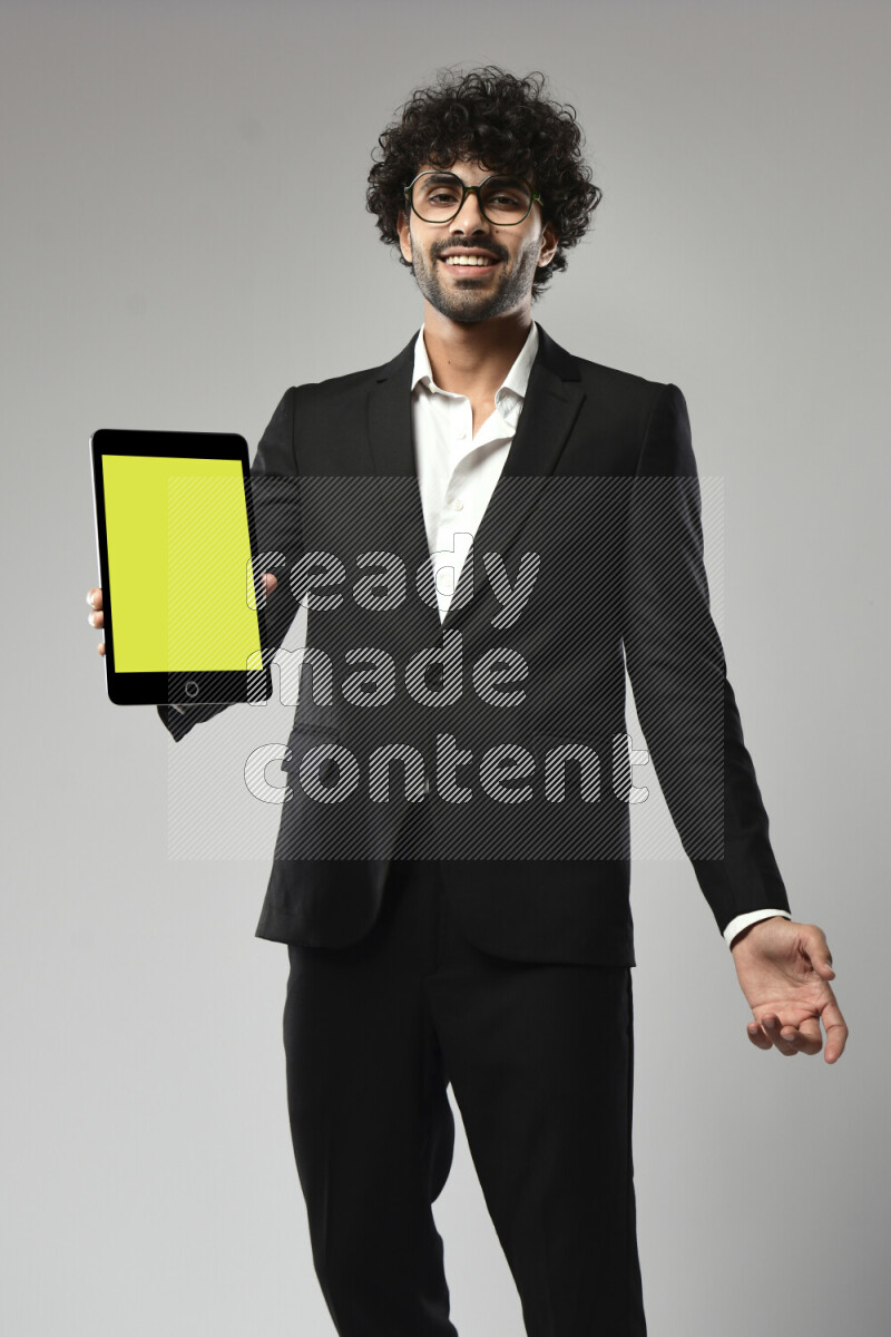 A man wearing formal standing and showing a tablet screen on white background