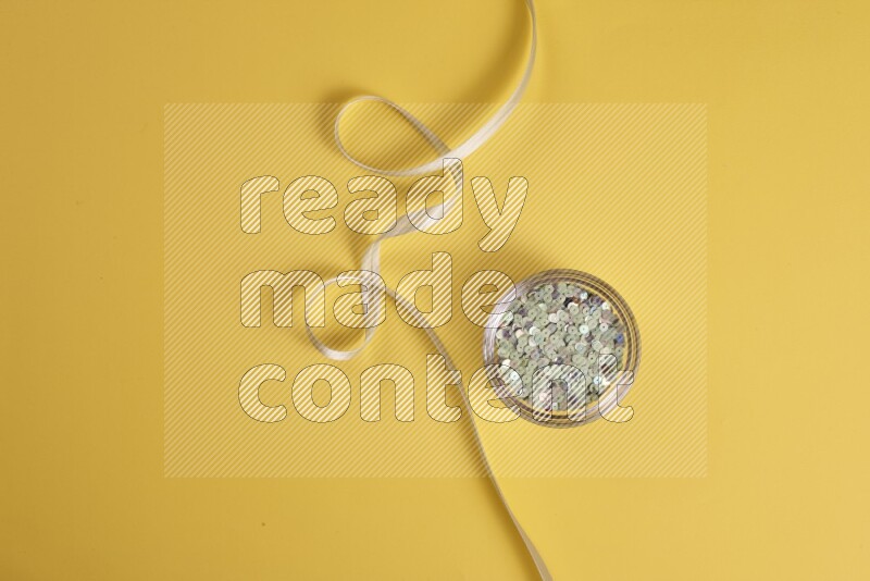 A green collection of sewing and tailoring tools arranged on a yellow background