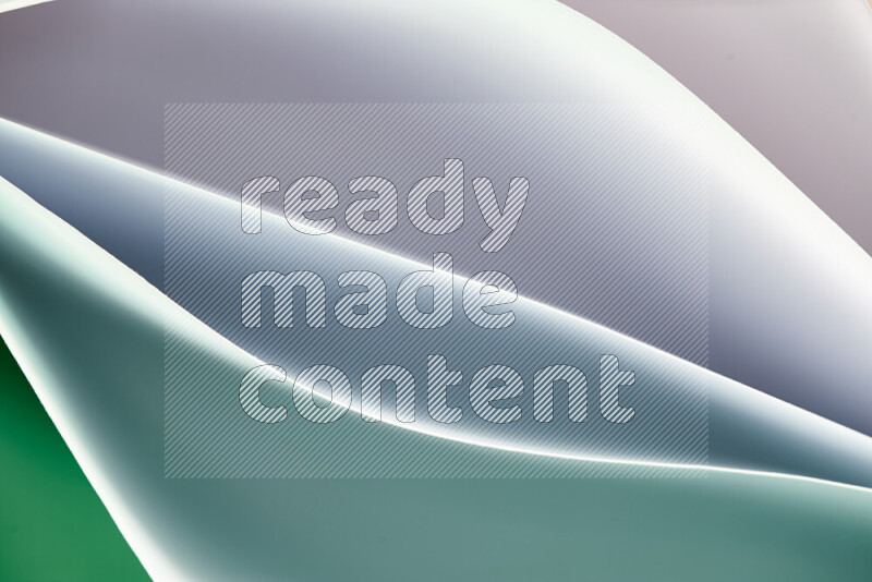This image showcases an abstract paper art composition with paper curves in green and white gradients created by colored light
