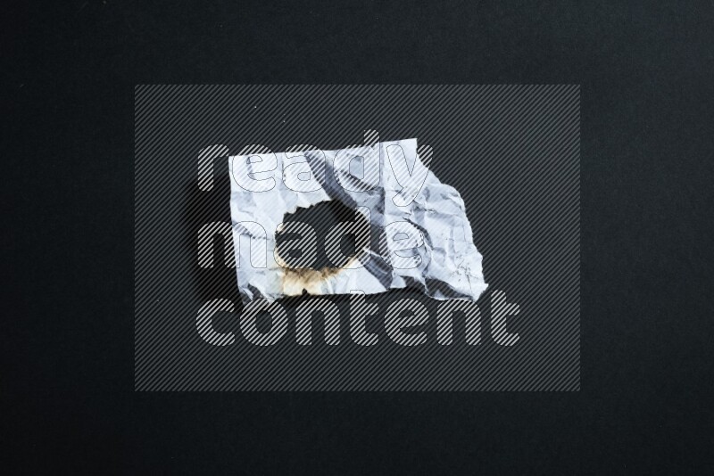 Burnt multicolored paper on black background