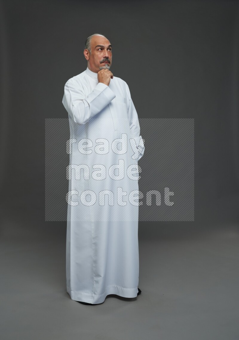 Saudi man without shomag Standing Interacting with the camera on gray background