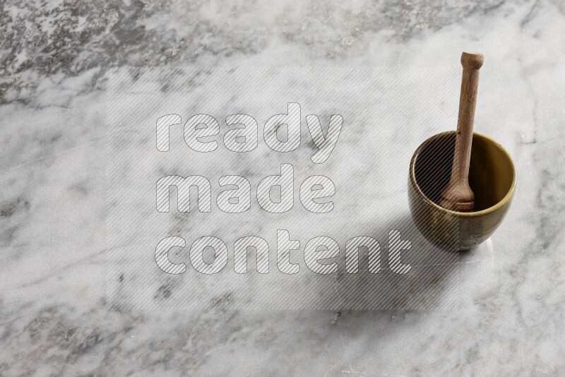 Multicolored pottery cup with wooden honey dipper in it on grey marble background