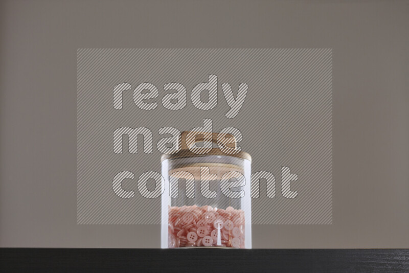 Buttons in a glass jar on black background