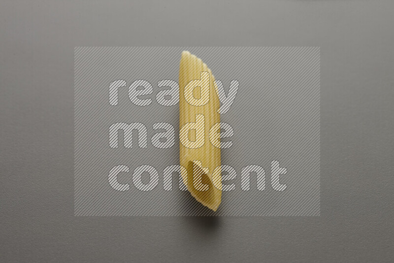 Penne pasta on grey background