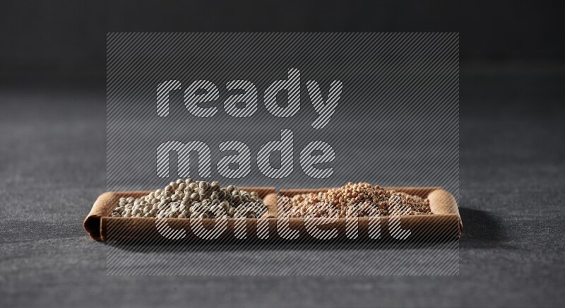 2 squares of cinnamon sticks full of mustard seeds and white peppers on black flooring