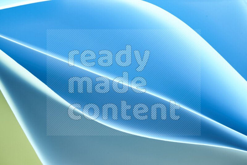 This image showcases an abstract paper art composition with paper curves in green and blue gradients created by colored light