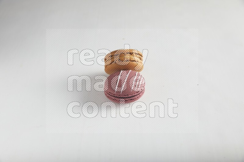 45º Shot of of two assorted Brown Irish Cream, and Red Poppy Flower macarons on white background