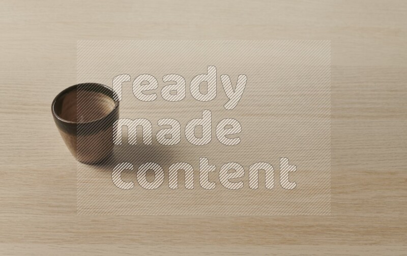 A pottery cup on light wooden background