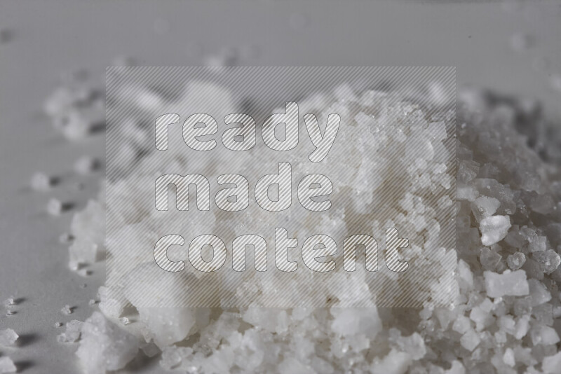 A bunch of coarse sea salt crystals on white background