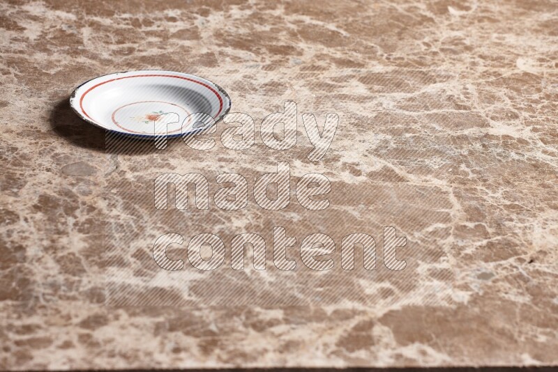 A vintage metal plate on beige marble background