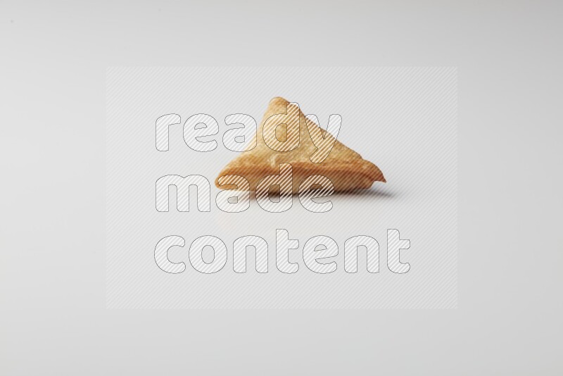 One fried sambosa on a white background