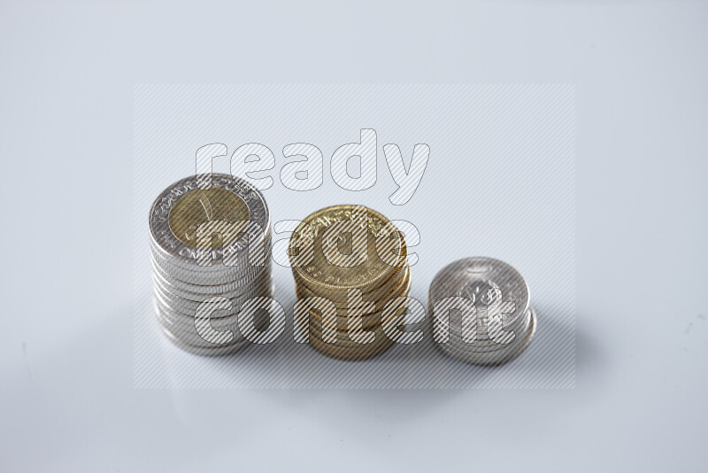 A close-up of scattered mixed Egyptian coins such as One pound, 50 and 25 piasters on grey background