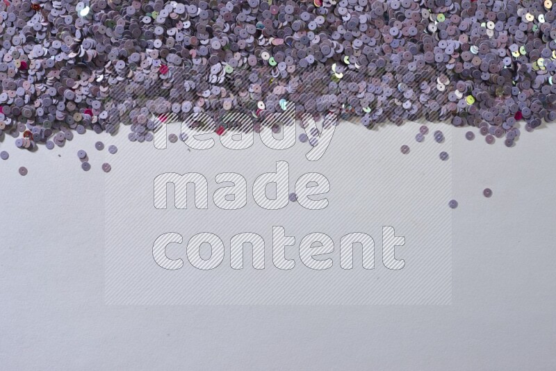 Multicolored flat sequins on grey background