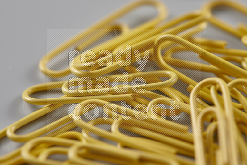 Yellow paper clips isolated on a grey background