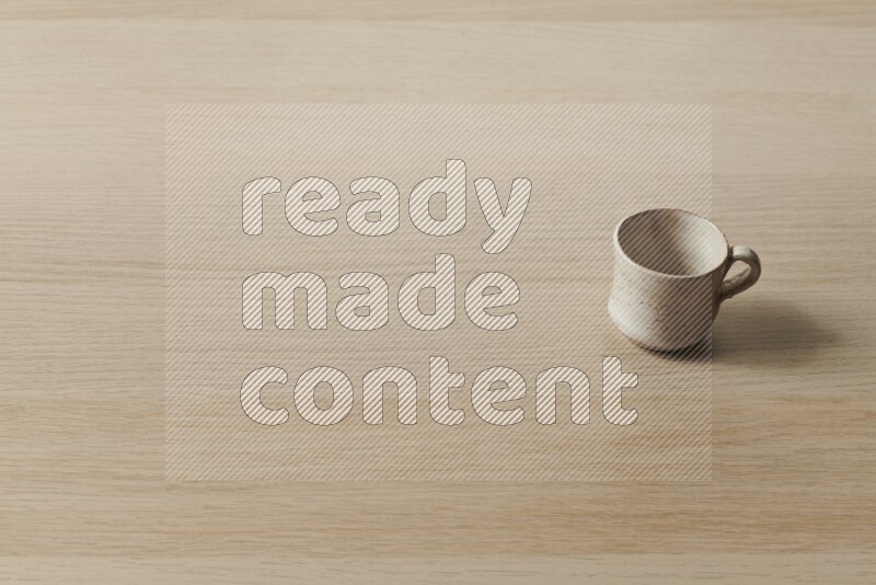 A pottery cup on light wooden background