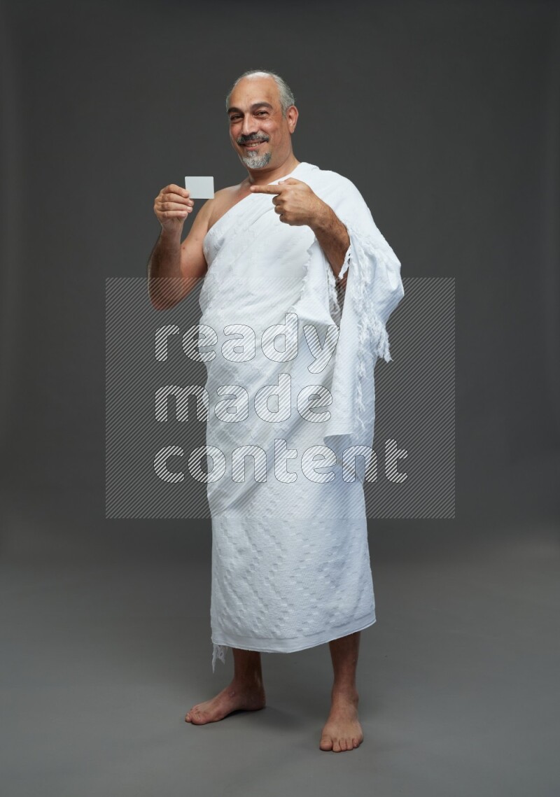 A man wearing Ehram Standing holding ATM card on gray background
