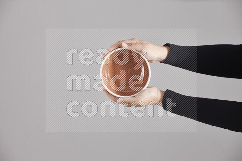 A woman in black abaya holding different pottery essentials in different positions