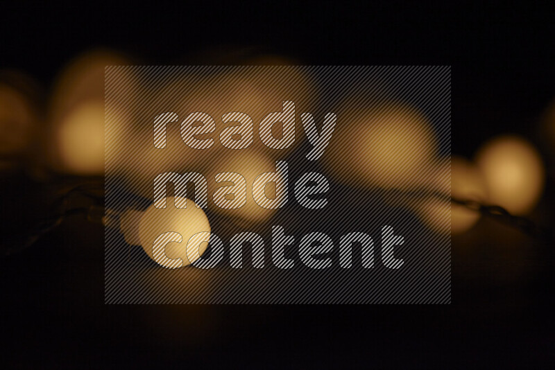 Light bulbs glowing against backdrop of golden bokeh