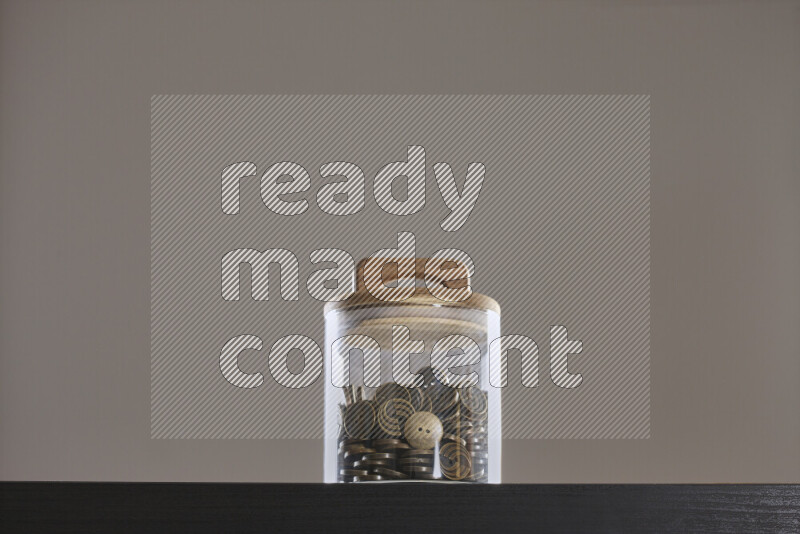 Buttons in a glass jar on black background