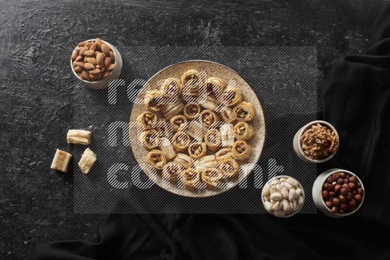 Oriental sweets in pottery plates with nuts in a dark setup