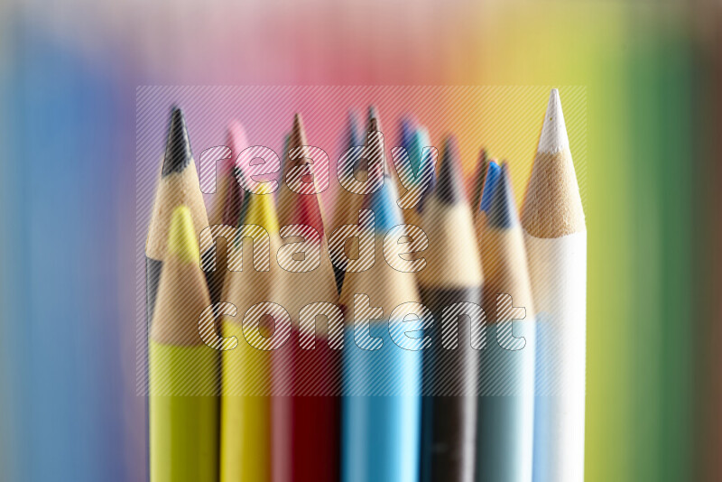 The image captures a close-up of sharpened colored pencils on multicolored background