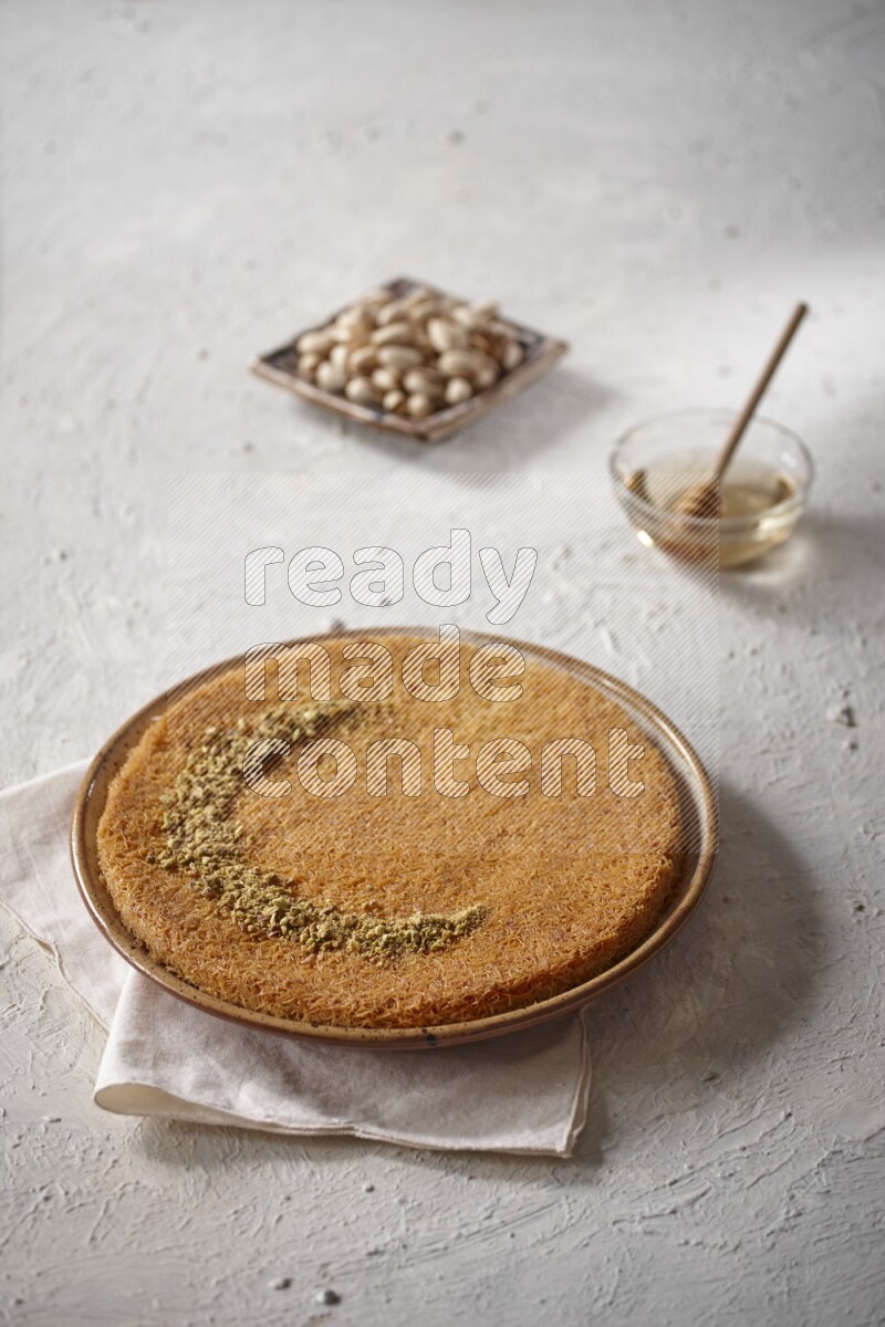 Konafa with nuts and honey in a light setup