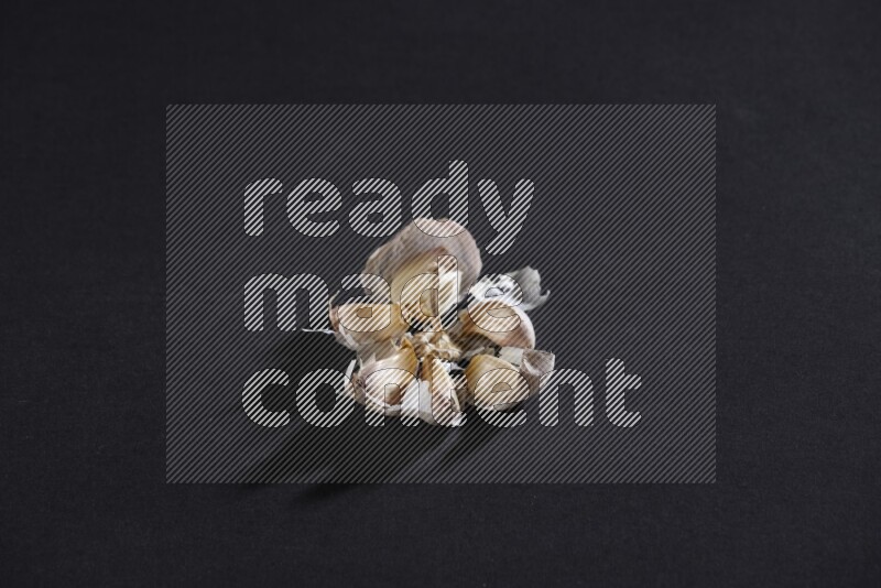 رأس ثوم مشقوقة تظهر الفصوص بداخلها على خلفية سوداء