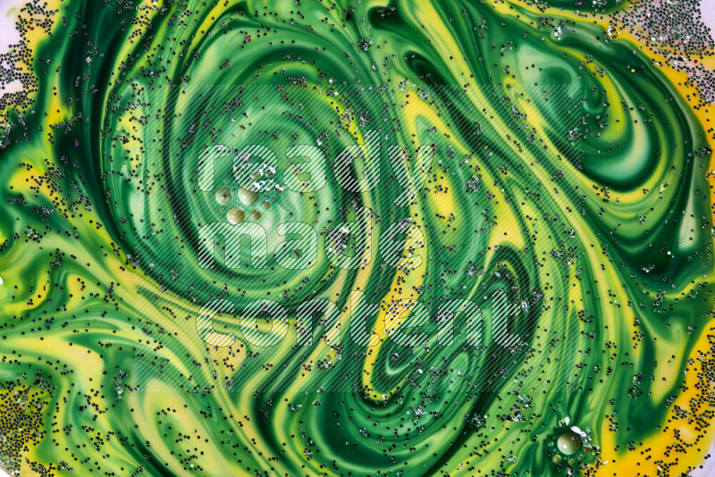 A close-up of sparkling green glitter scattered on swirling yellow and green background