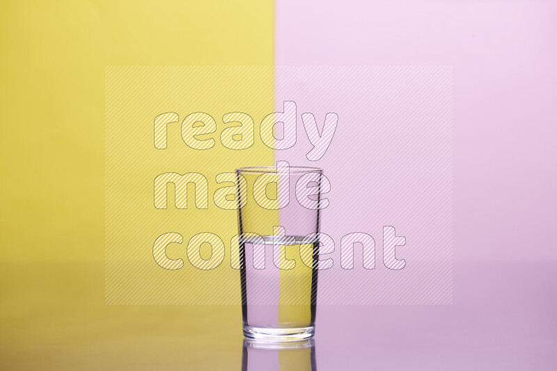 The image features a clear glassware filled with water, set against yellow and rose background