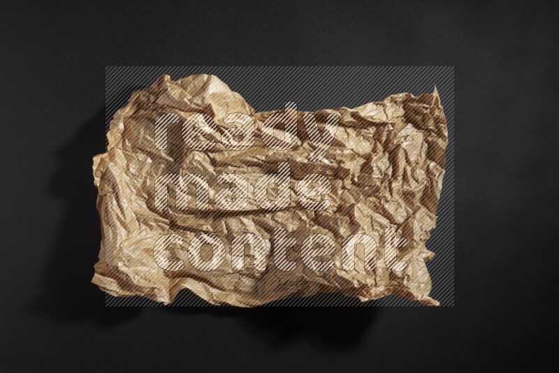 Crumpled craft paper on black background
