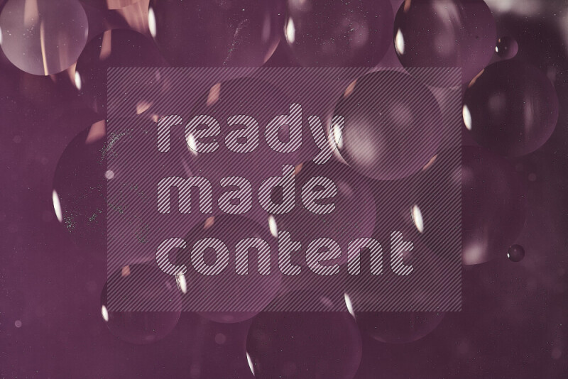 Close-ups of abstract oil bubbles on water surface in shades of purple