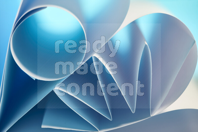 عرض فني لطيات الورق تخلق مزيج من الأشكال الهندسية، مضاءة بإضاءة ناعمة بدرجات اللون الأزرق والأبيض