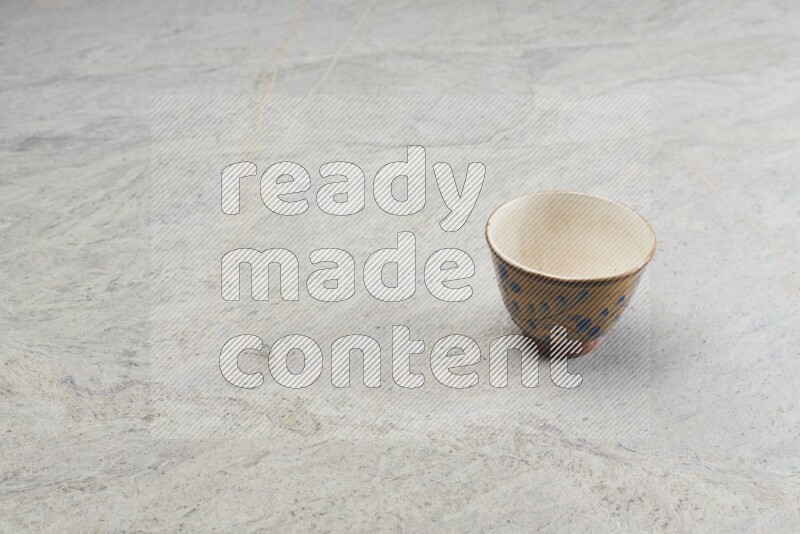 A multicolored pottery bowl on grey marble background