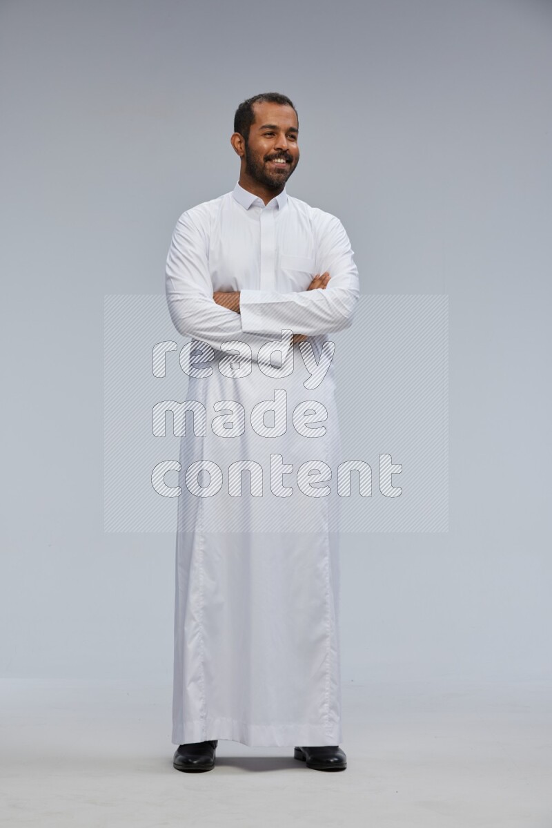 Saudi man wearing Thob standing with crossed arms on Gray background