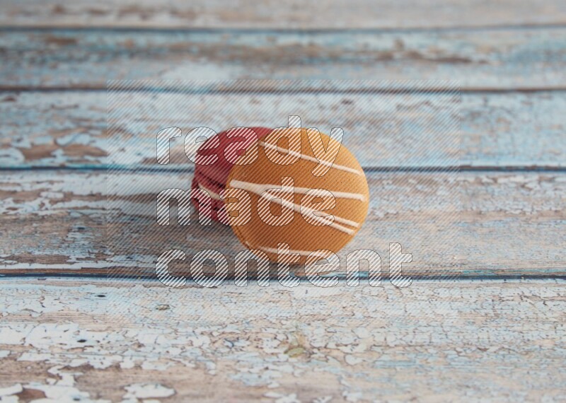 45º Shot of of two assorted Brown Irish Cream, and Red Velvet macarons on light blue background