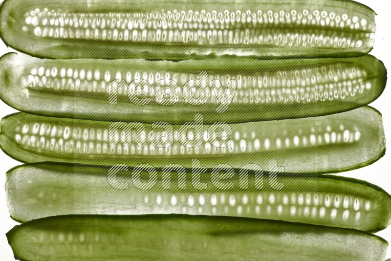 Cucumber slices on illuminated white background