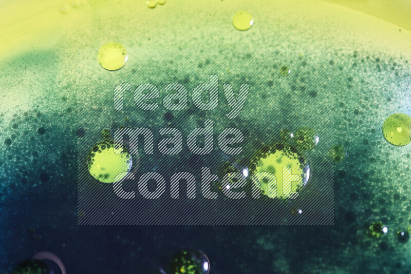 لقطات مقربة لقطرات ألوان مائية صفراء وزرقاء وخضراء على سطح الزيت على خلفية بيضاء