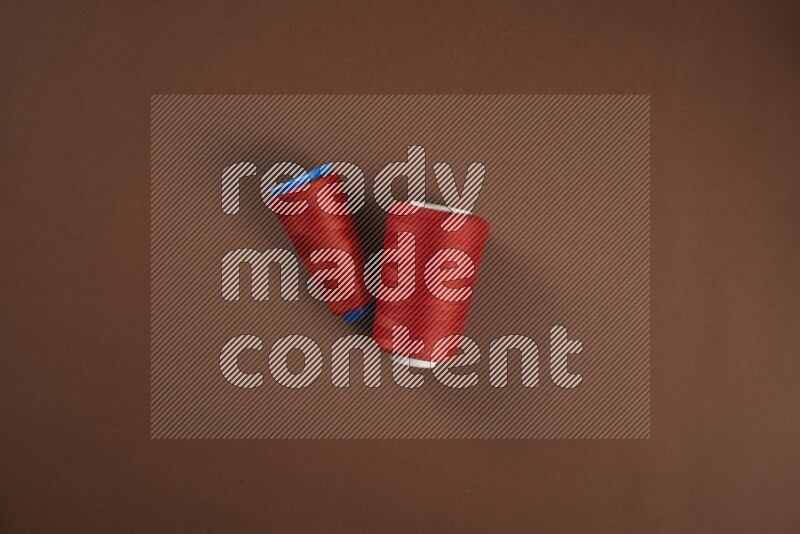 مجموعة من أدوات الخياطة والتفصيل حمراء اللون على خلفية بنية