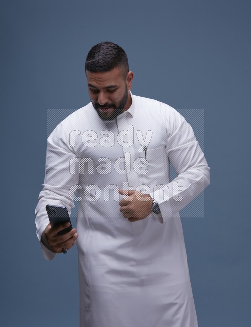 A Saudi man Taking A Selfie on Blue Background wearing Saudi Thob
