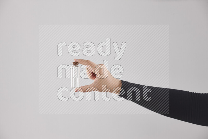 A woman in black abaya holding different glassware in different positions